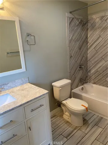 a bathroom with a granite countertop toilet sink and a bathtub