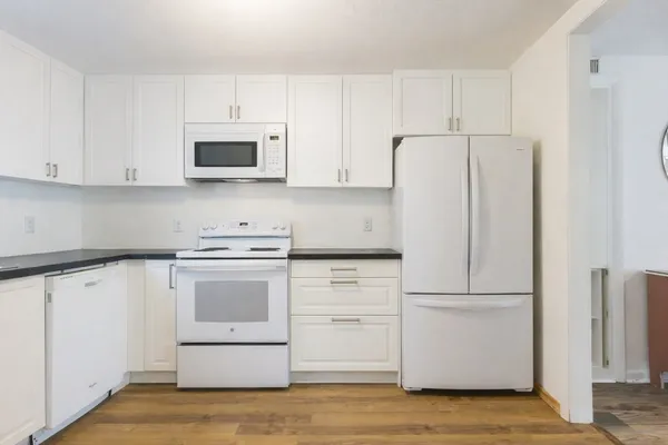 a kitchen with white cabinets and white appliances
