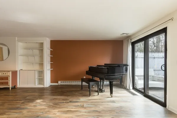 a view of a livingroom with wooden floor and a piano