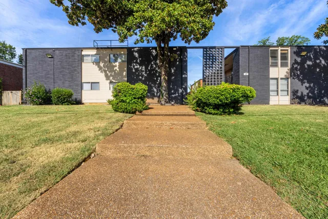 a view of a house with a yard and potted plants