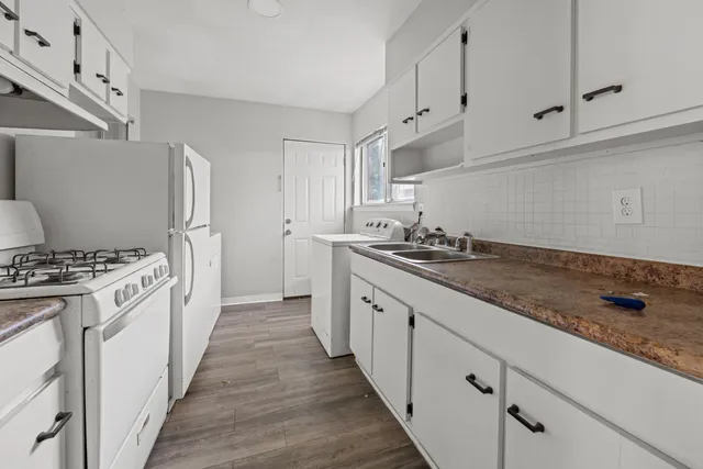 a kitchen with granite countertop white cabinets and white appliances