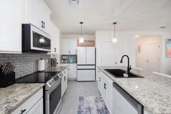 a kitchen with a sink stove and microwave