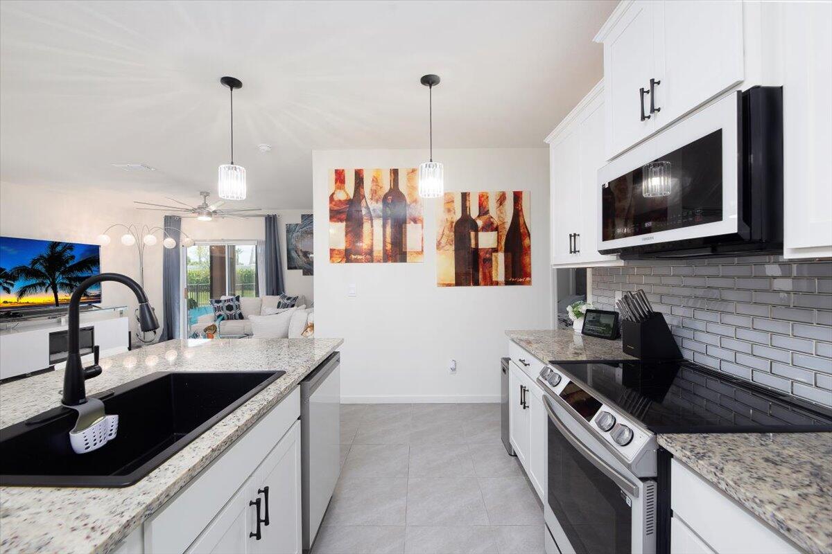 12314 Rimini Way Port St. Lucie, FL 34987 - Photo 15 of 49 a kitchen with a sink stove and microwave