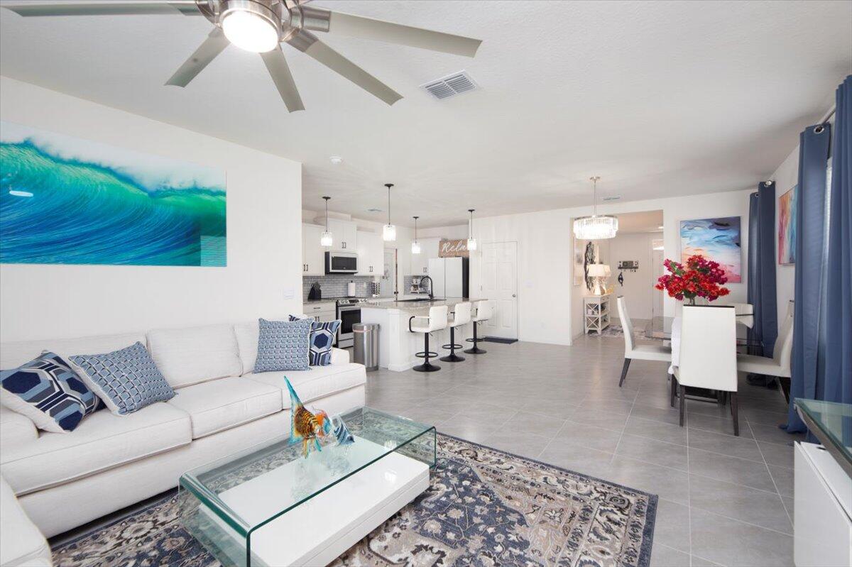 12314 Rimini Way Port St. Lucie, FL 34987 - Photo 20 of 49 a living room with furniture and a chandelier