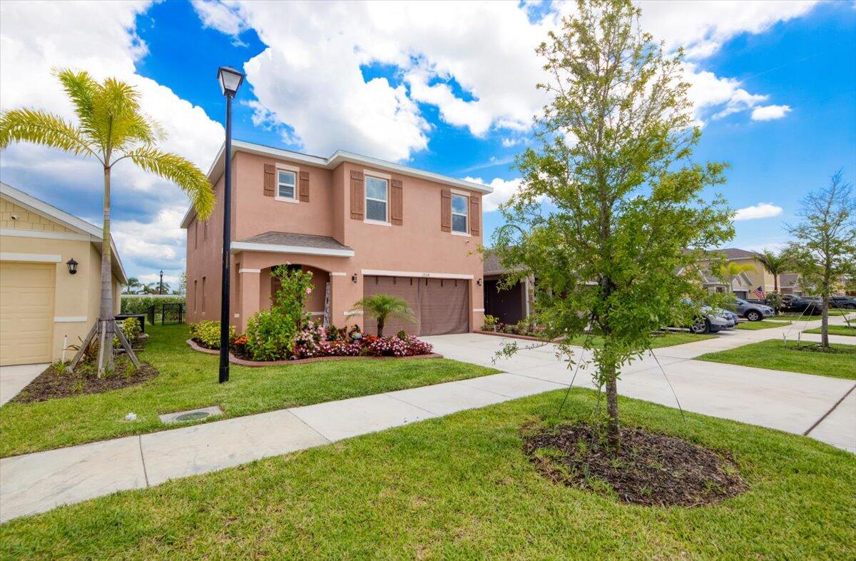 12314 Rimini Way Port St. Lucie, FL 34987 - Photo 2 of 49 a front view of a house with garden