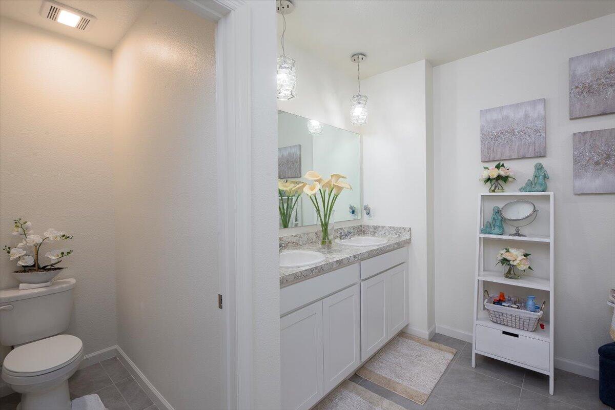 12314 Rimini Way Port St. Lucie, FL 34987 - Photo 29 of 49 a bathroom with a granite countertop sink a toilet and a shower