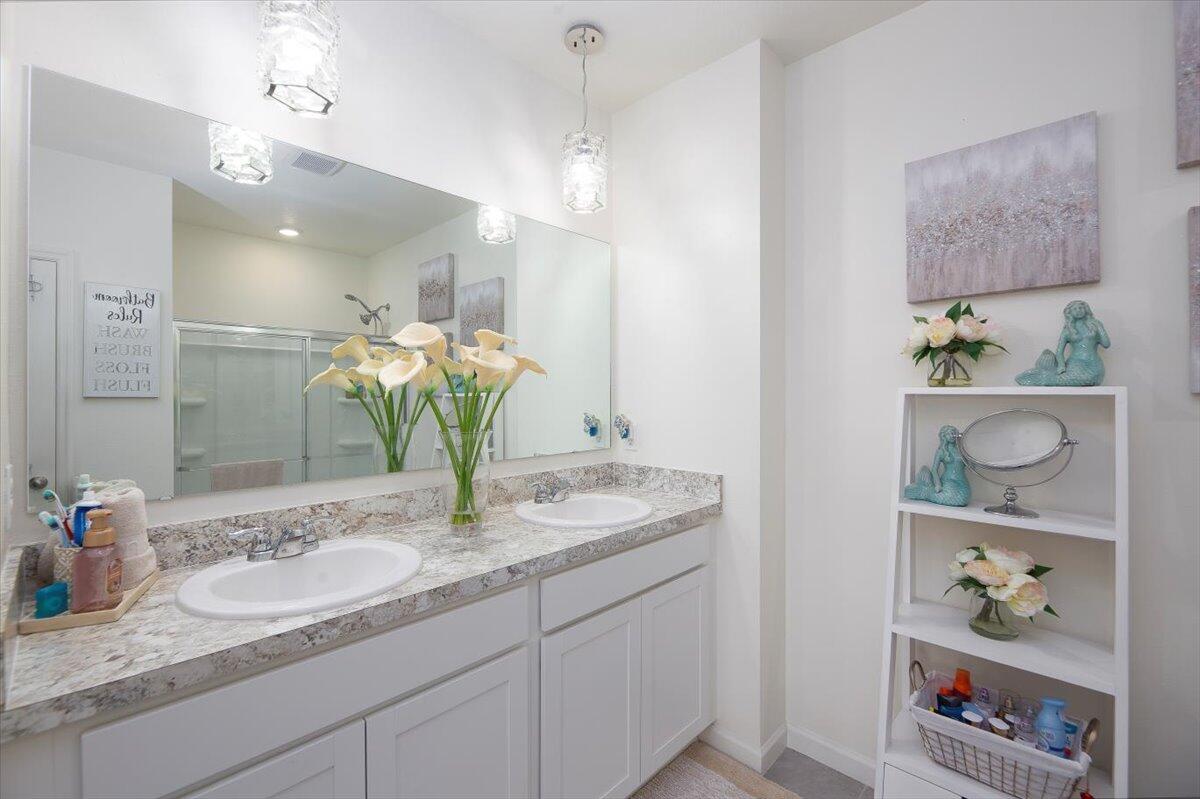 12314 Rimini Way Port St. Lucie, FL 34987 - Photo 30 of 49 a bathroom with a granite countertop sink a toilet and a mirror