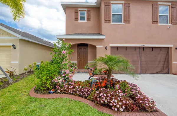 a front view of a house with a yard and potted plants