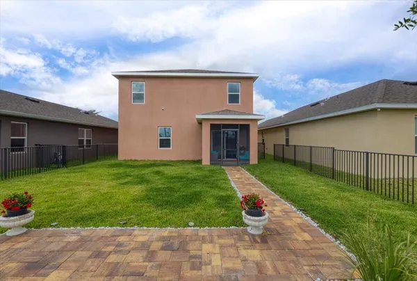 an aerial view of a house with front yard and outdoor seating