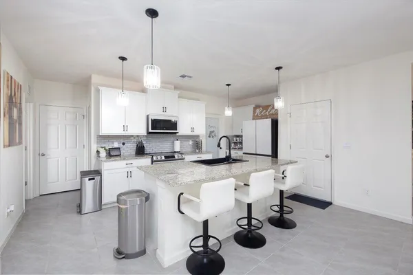 a kitchen with granite countertop a sink and a stove top oven with wooden floor