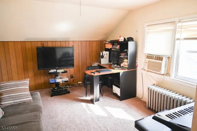 a view of a workspace with furniture and a flat screen tv