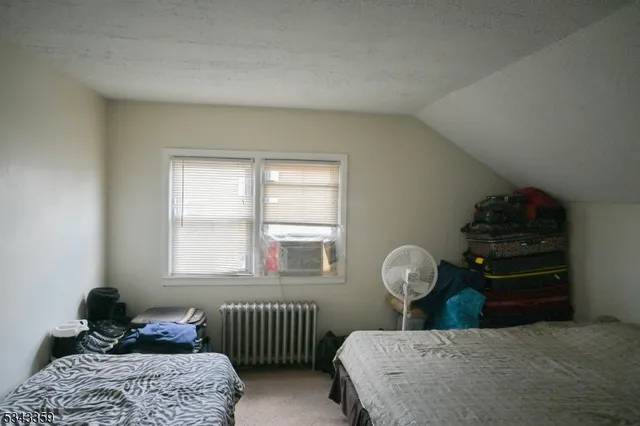 a bedroom with a bed and a lamp on dresser