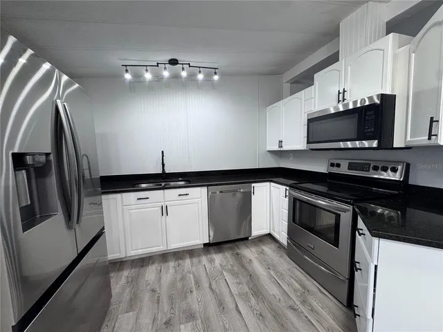 a kitchen with a sink and steel stainless steel appliances