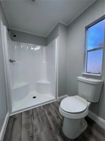 a bathroom with a toilet and a shower