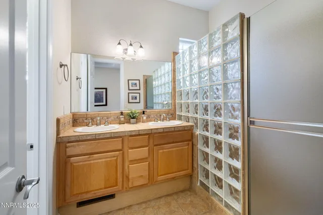 a spacious bathroom with a shower sink and mirror