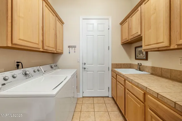 a utility room with cabinets washer and dryer