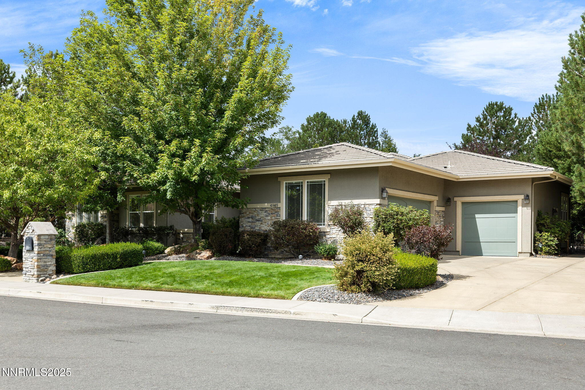 4865 Buckhaven Road Reno, NV 89519 - Photo 46 of 47 a front view of a house with a yard and potted plants