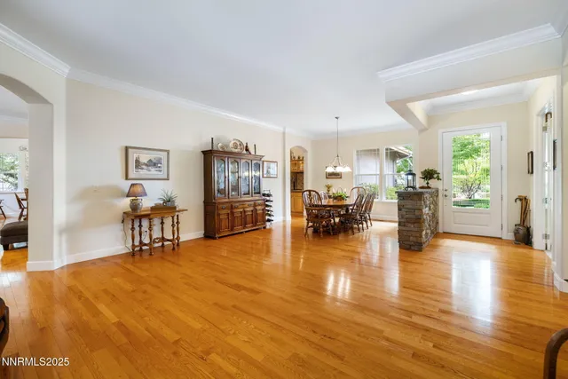 a livingroom with furniture and a dining table with wooden floor