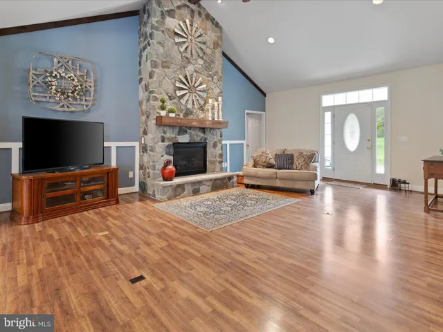 a kitchen with stainless steel appliances granite countertop wooden cabinets a sink dishwasher a stove and a refrigerator with wooden floor