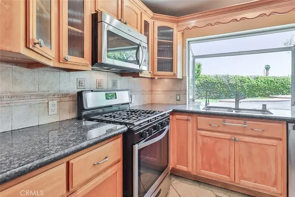 a kitchen with stainless steel appliances granite countertop a stove and a microwave