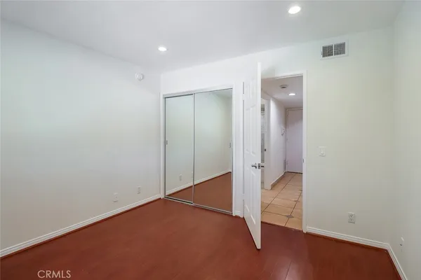 an empty room with wooden floor and a hallway