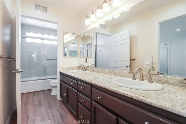 a bathroom with a granite countertop sink a toilet and shower