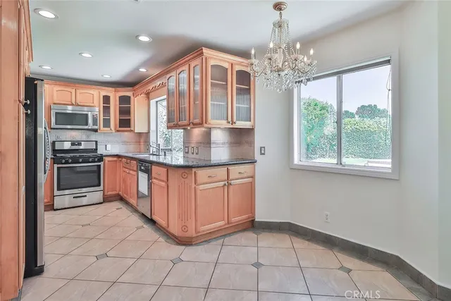 a kitchen with stainless steel appliances granite countertop a stove a sink and a microwave