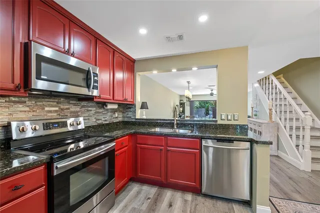 a kitchen with stainless steel appliances granite countertop a stove microwave and sink