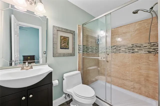 a bathroom with a sink a toilet a mirror and shower