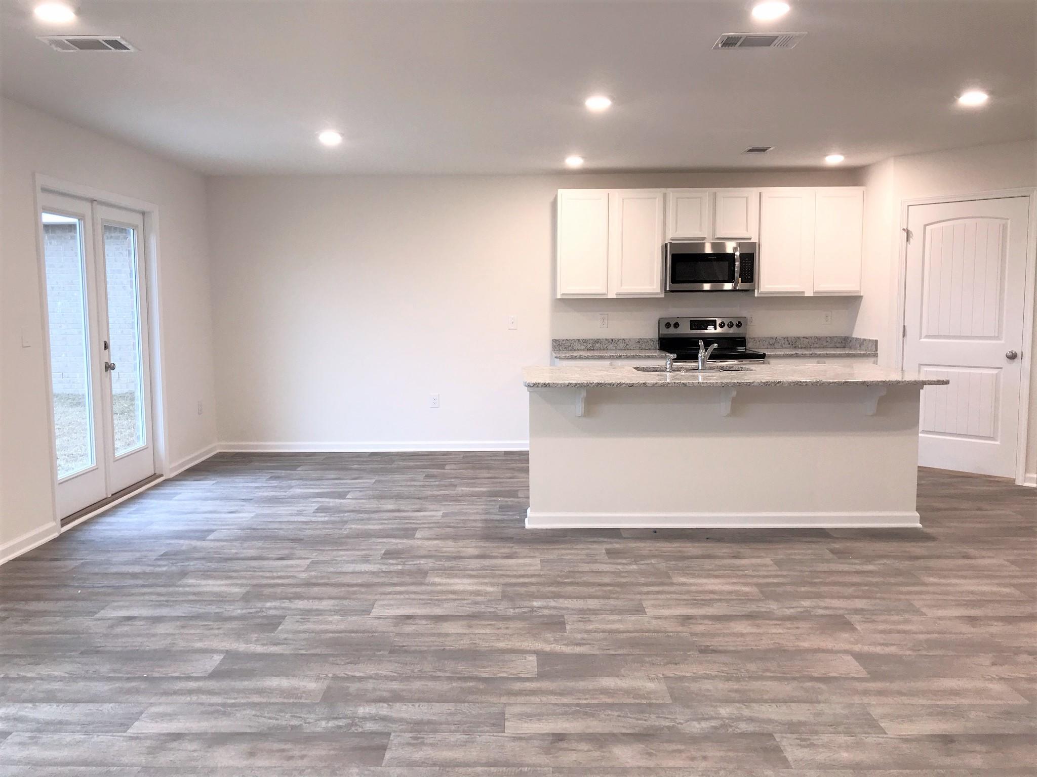 320 Flounder Street Crestview, FL 32539 - Photo 5 of 18 a large kitchen with kitchen island a sink wooden floor and stainless steel appliances