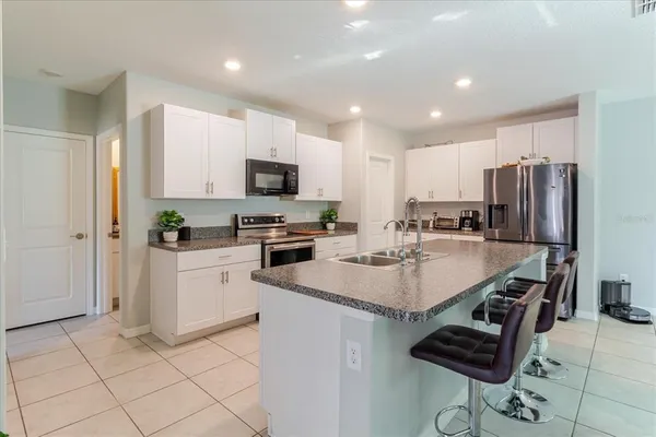 a kitchen with granite countertop a sink stainless steel appliances and white cabinets