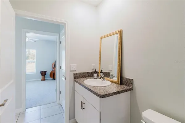 a white toilet sitting next to a bathroom sink and vanity