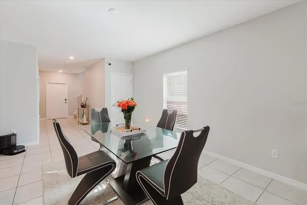 a living room with furniture kitchen view and a potted plant