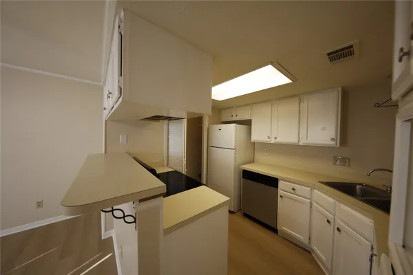 a kitchen with a refrigerator sink and cabinets