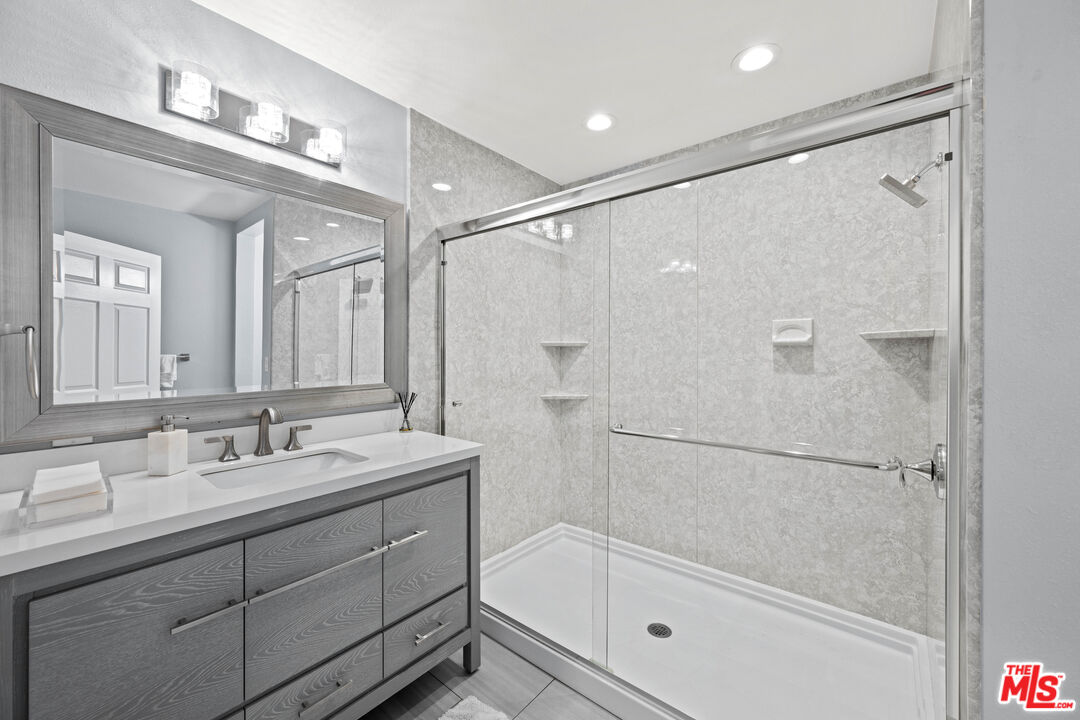 15042 Valleyheart Drive Sherman Oaks, CA 91403 - Photo 15 of 31 a bathroom with a bathtub shower sink vanity and mirror