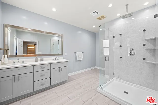 a spacious bathroom with a granite countertop sink a mirror a shower and a bathtub