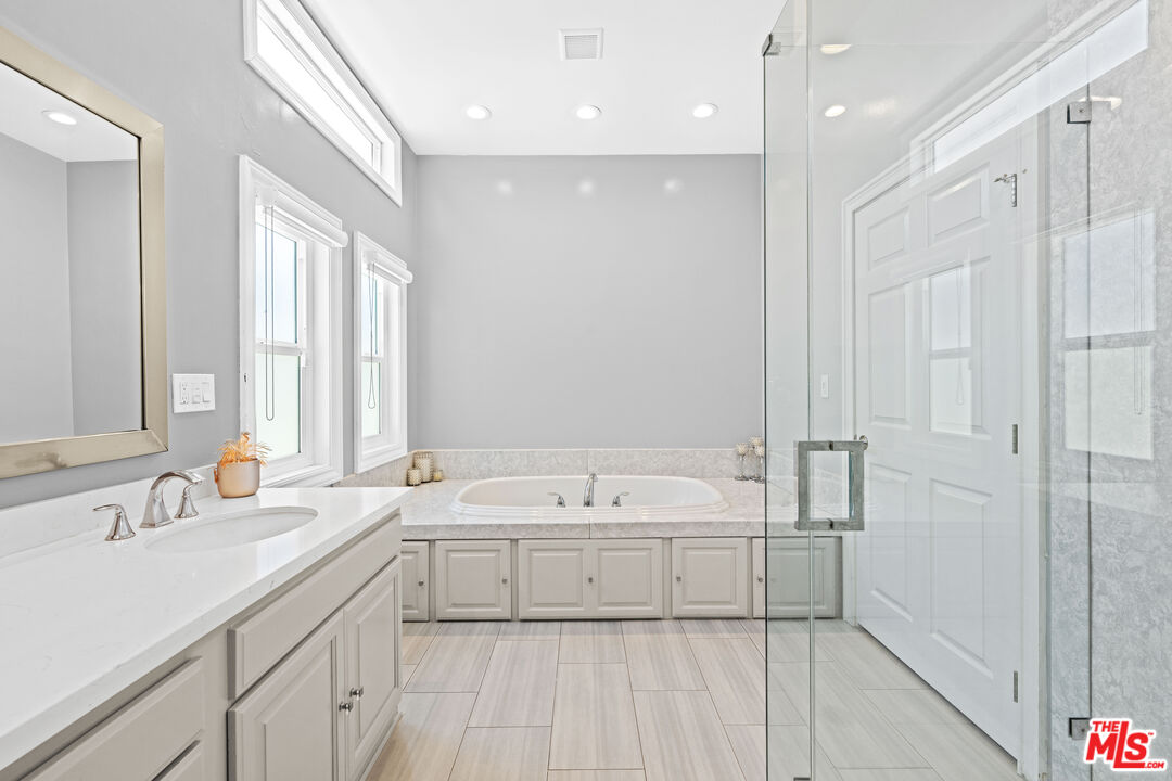 15042 Valleyheart Drive Sherman Oaks, CA 91403 - Photo 22 of 31 a bathroom with a tub a sink and mirror