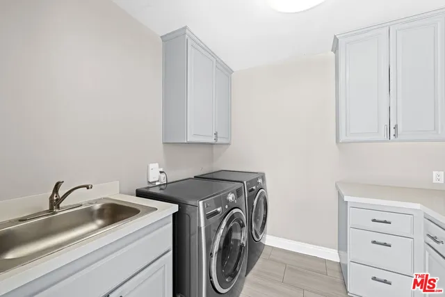 a utility room with sink dryer and washer