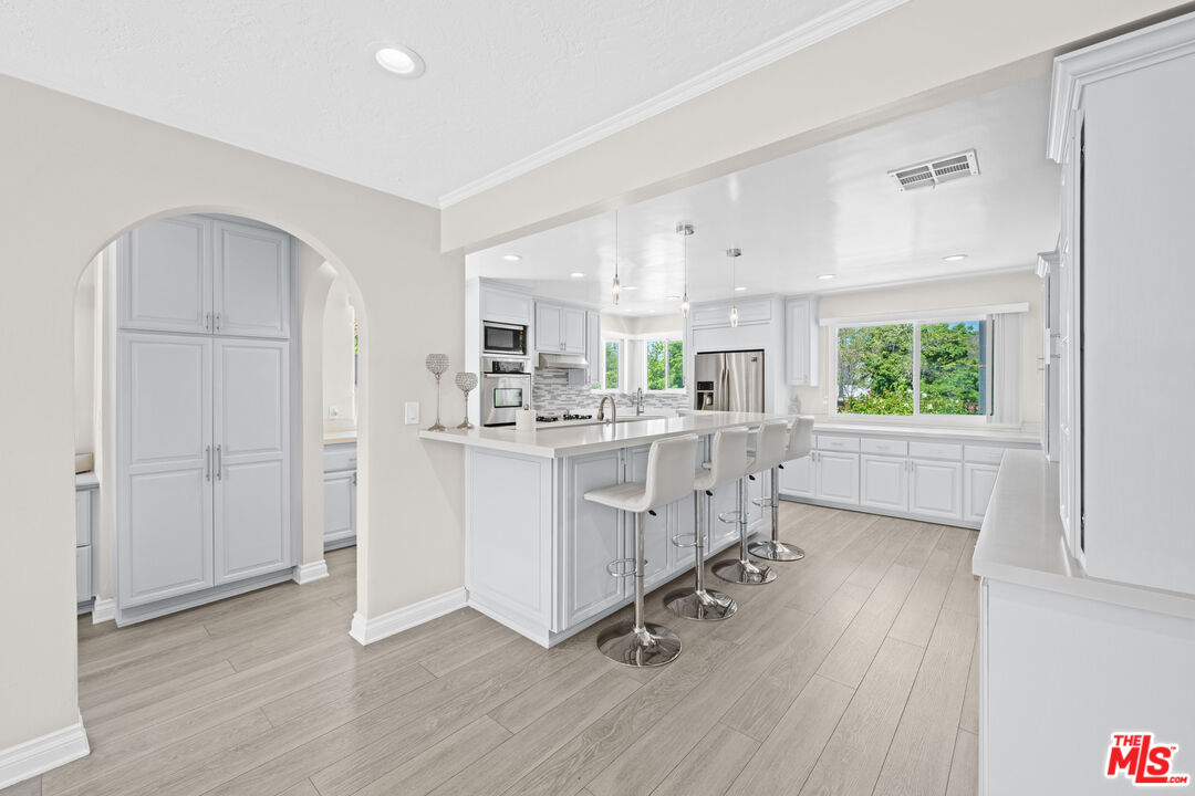 15042 Valleyheart Drive Sherman Oaks, CA 91403 - Photo 6 of 31 a kitchen with white cabinets and window