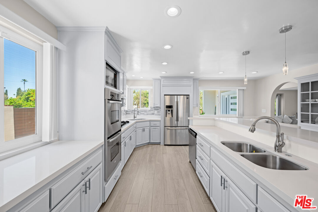 15042 Valleyheart Drive Sherman Oaks, CA 91403 - Photo 7 of 31 a large white kitchen with a large window