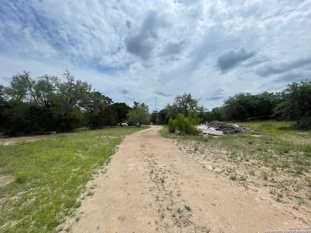 a view of a dry yard with wooden fence