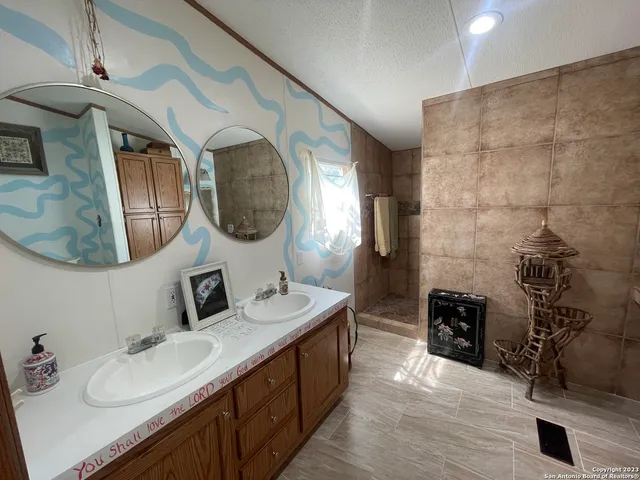 a bathroom with double vanity and a mirror