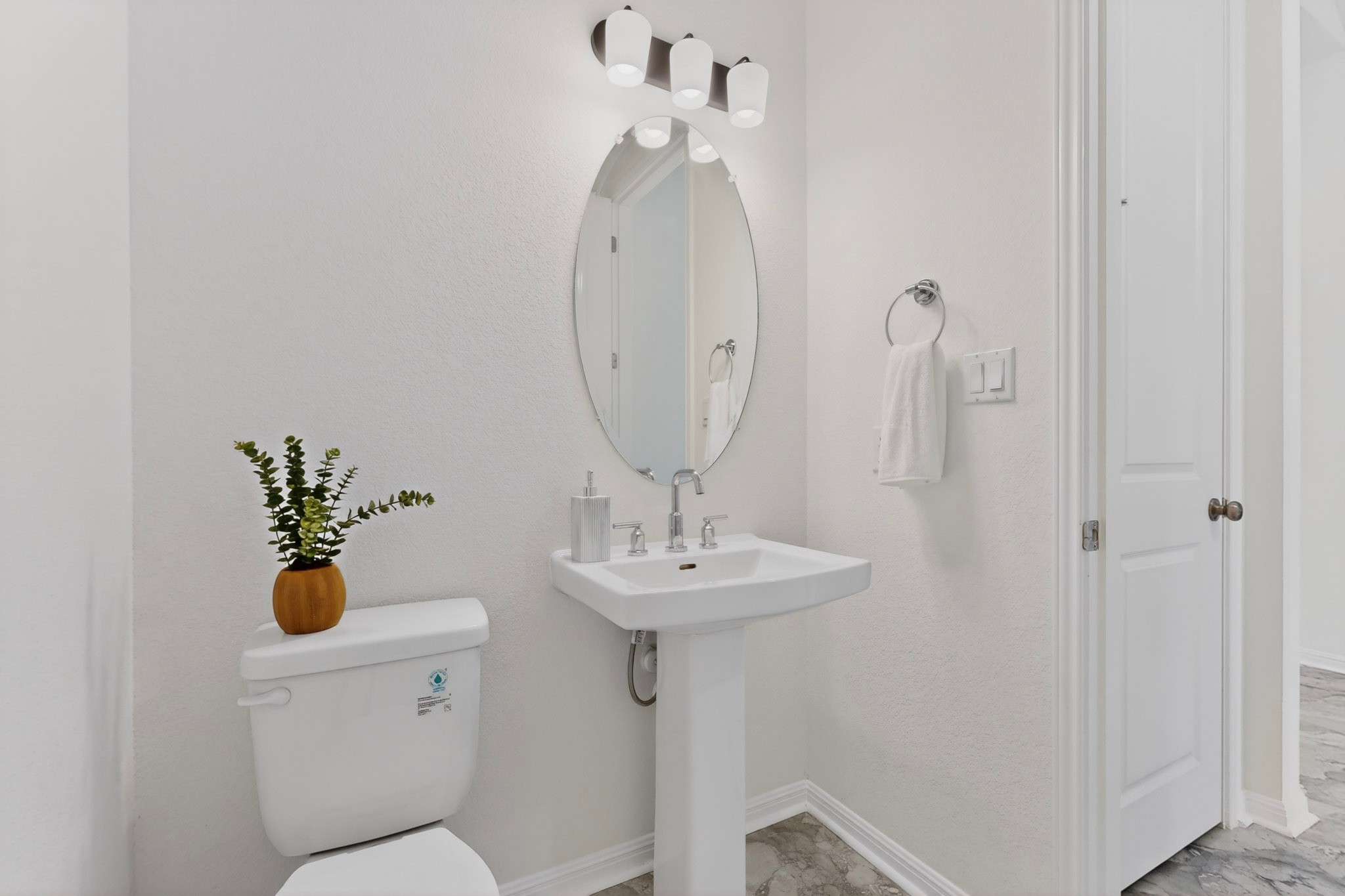 2308 Mondello Path Leander, TX 78641 - Photo 10 of 39 A well-appointed powder room features a pedestal sink and modern lighting.