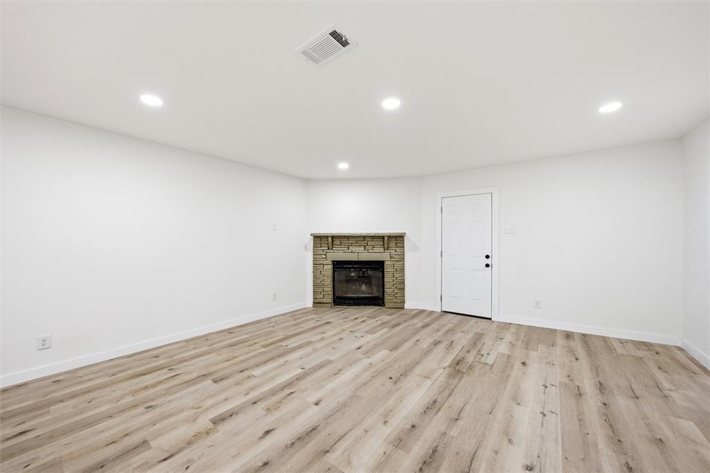 1221 Chestnut Street Waco, TX 76704 - Photo 12 of 32 a view of an empty room with wooden floor and a fireplace