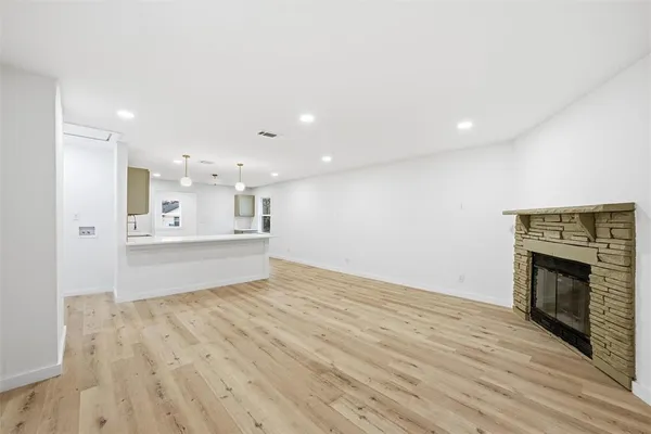 a view of kitchen with kitchen island wooden floor and living room
