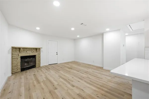 a view of an empty room with a fireplace and a window