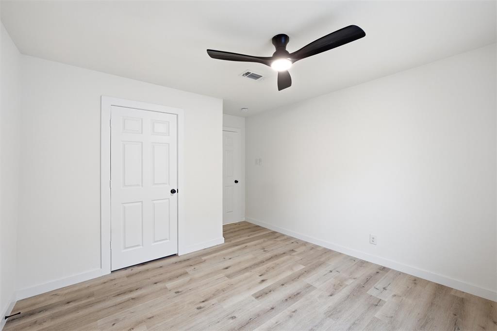 1221 Chestnut Street Waco, TX 76704 - Photo 20 of 32 an empty room with wooden floor ceiling fan and windows