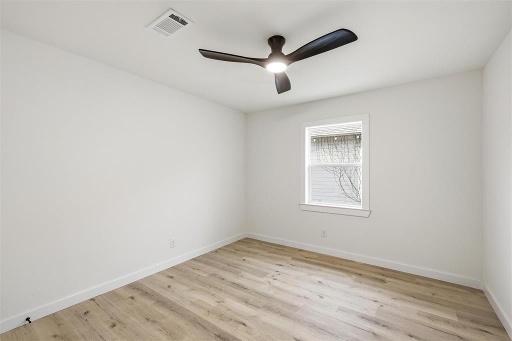 1221 Chestnut Street Waco, TX 76704 - Photo 22 of 32 an empty room with wooden floor ceiling fan and windows