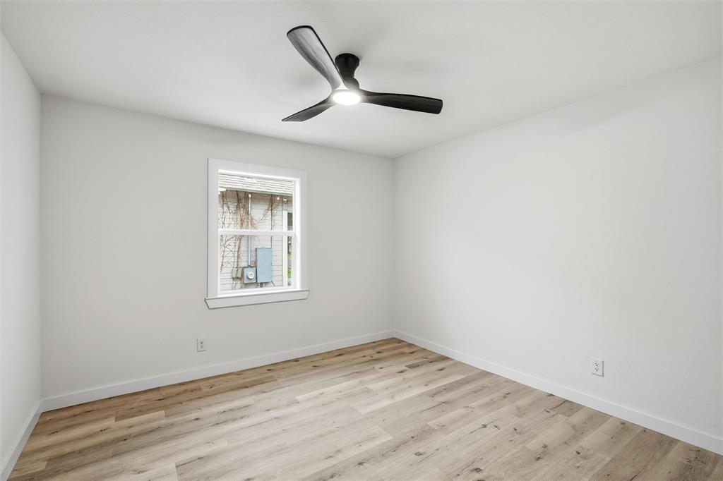 1221 Chestnut Street Waco, TX 76704 - Photo 25 of 32 an empty room with wooden floor ceiling fan and window