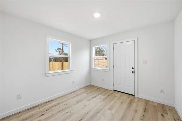 an empty room with a window and wooden floor